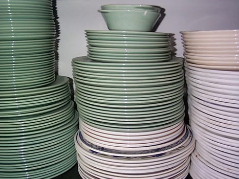 Stacked dinner plates of different size on a shelf