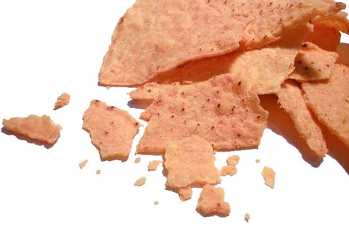 Closeup of a crushed potato crisp with seasoning scattered on a white background