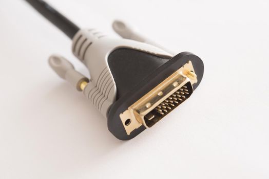 Dual link DVI video interface plug with white rubber body with black cord close-up on white background