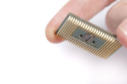 Close up macro view of a computer microprocessor held between the fingers of person over white with copy space