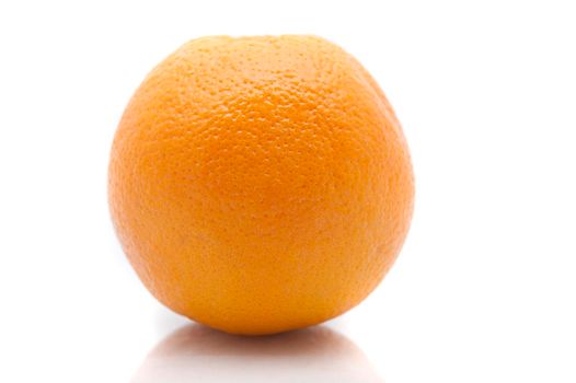 Close up view of one whole fresh orange showing the texture of the rind over a white background