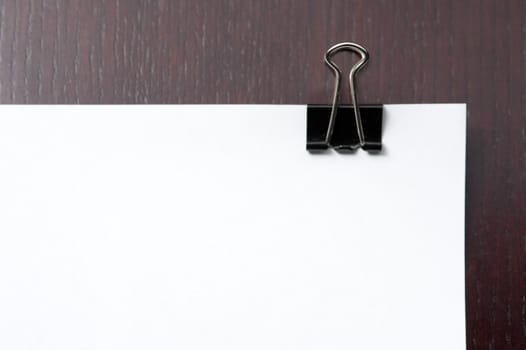 Binder clip on blank white paper with copy space