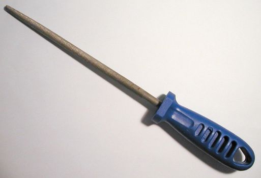 File augur with a tapering point, rasping surface and blue plastic handle lying diagonally on white in a DIY concept