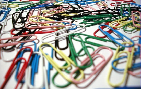 Pile of colorful paperclips in a school or office stationery supply viewed low angle with shallow dof