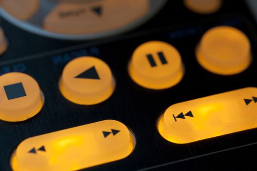 Illuminated media playback buttons detail with pause, forward or play and stop controls in a personal entertainment concept