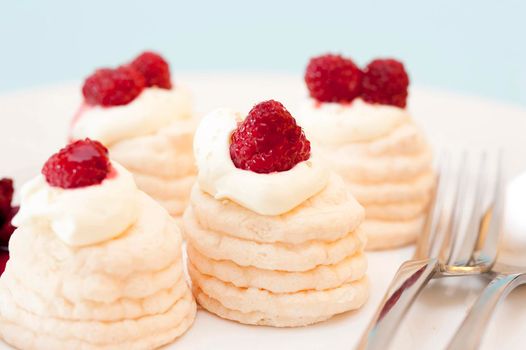 Decorative twirled cone meringues filled with fresh whipped cream and topped with ripe red strawberries