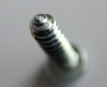 Abstract screw with focus to the tip of the spiral thread as it stands in an upright position