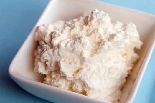 Dish of fresh cottage cheese made from the curds of skimmed milk for a healthy snack or accompaniment