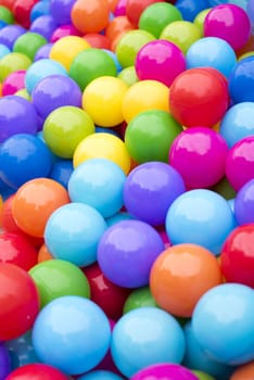 A close up of multicoloured plastic balls in a ball pit.