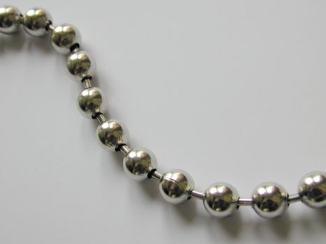 Top down view on close up of chrome finished balls attached to one another in metal necklace