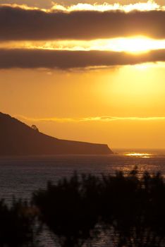 a beautiful golden yellow sunset over california big sur coastline