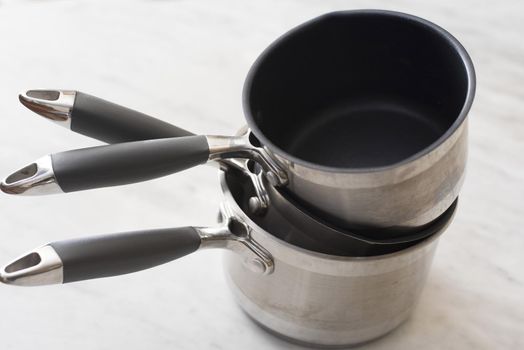Three clean empty stainless steel pots with non-stick interiors stacked on top of each other