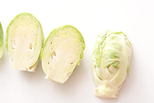 A close up of halved brussel sprouts on a white background.