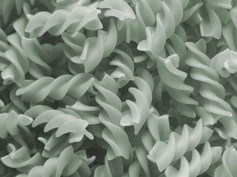 Monochrome fusilli pasta background texture with the traditional spiral twisted Italian noodles in a random jumble