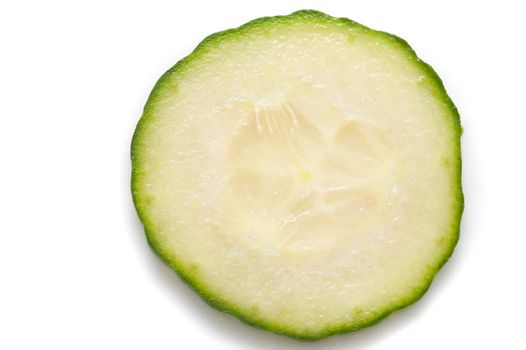 Single thin slice of fresh cucumber prepared for a salad showing the texture of the juicy fleshy pulp, pips and rind on white