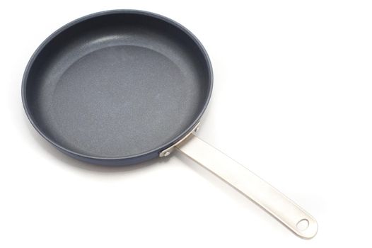 Empty clean non-stick frying pan on white arranged diagonally across the frame with copy space