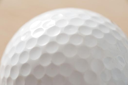 Close up detail of a white golf ball showing the dimpled texture of the surface in a golfing or sporting concept