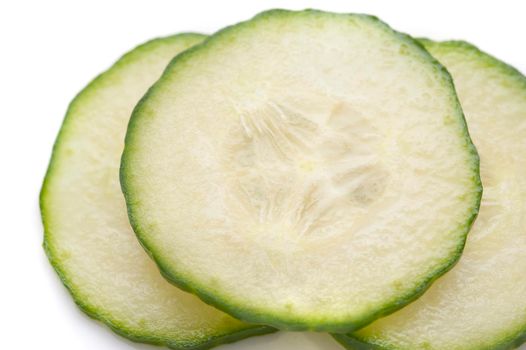Close up of thinly sliced cucumber showing pip, pulpy flesh and rind detail for use as a salad ingredient