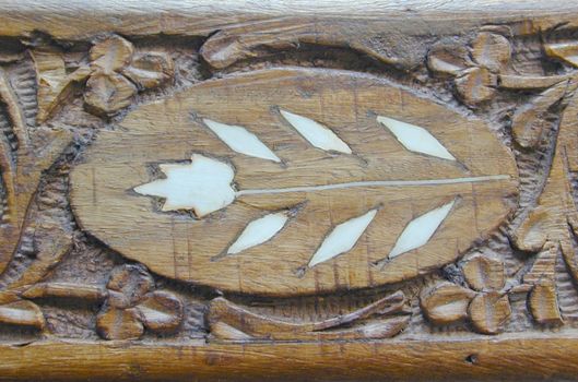 a carved wooden surface with shell inlay