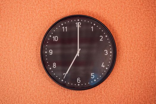 Classic black and white analog clock on red background at One o'clock with copy space.