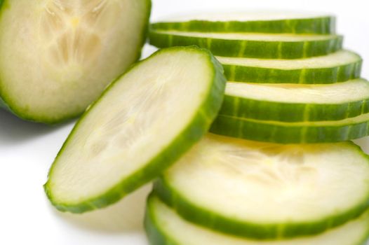 Closeup view of succulent thinly sliced cucumber being prepared as a salad ingredient or for healthy vegetarian cuisine