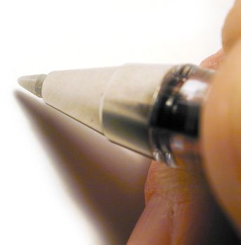 Extreme close up on fingers holding ball point pen over blank white paper as if to write something