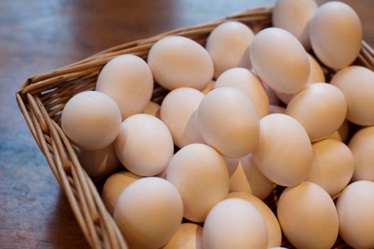 Farm fresh hens eggs displayed in a wicker basket at a farmers market for a healthy breakfast or to use as an ingredient in cooking and baking