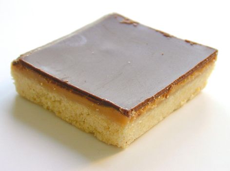 Slice of freshly baked delicious caramel shortcake on a white background