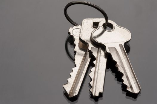 a metal keyring and three keys on a dark surface