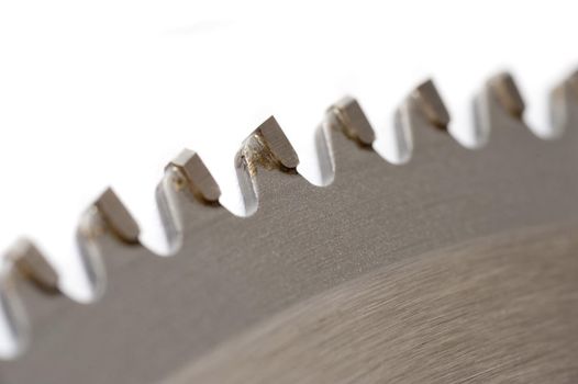 Detail of the sharp steel teeth on a new circular saw blade for woodworking isolated on white in a partial view
