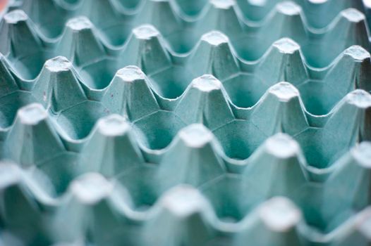 Low angle background view with shallow dof of an empty cardboard egg carton with divisions for the eggs