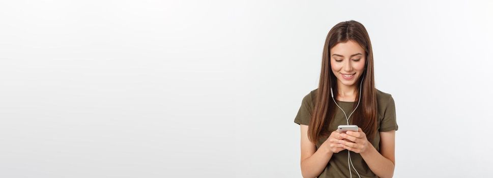 Portrait of a cheerful cute woman listening music in headphones and dancing isolated on a white background