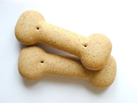 Closeup of two bone shaped dog biscuits providing a healthy nutrition for your pet on a white background