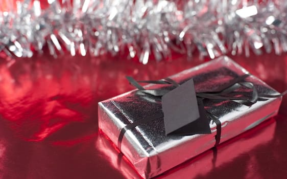 a christmas present wrapped in metallic foil wrapping paper and ribbon