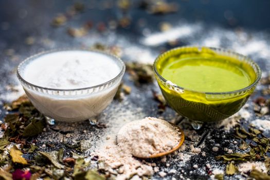 Neem or Indian Lilac face mask on the black wooden surface for acne and scars consisting of gram flour, neem paste, and some curd.