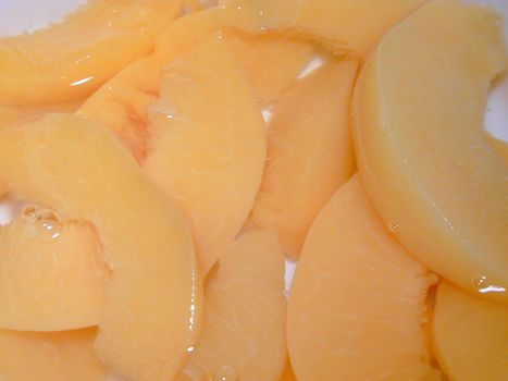 Background texture of canned peach slices in juice ready to be served for dessert