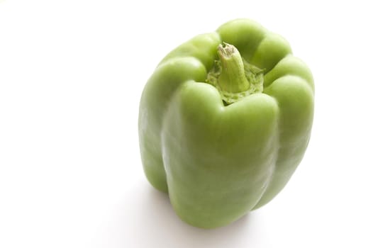 Fresh whole raw green bell pepper, sweet pepper or capsicum on a white background with copyspace, high angle view