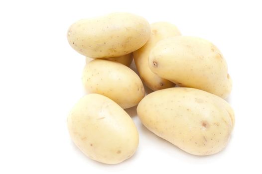 Pile of farm fresh cleaned fresh whole potatoes from farmers market isolated on white with copyspace