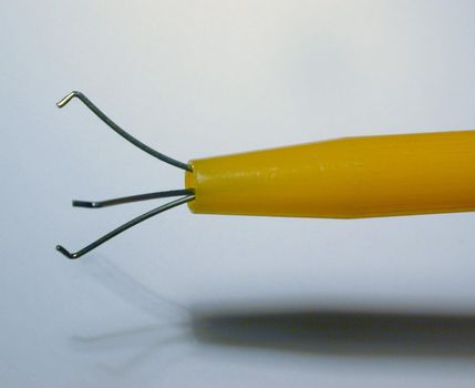 Extendable yellow plastic pearl or gemstone grips in close up over a white background with shadow and copy space