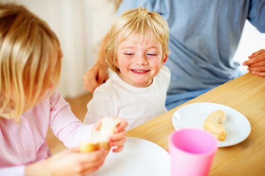 Smiling little boy with his family having breakfast. Portrait of a smiling little boy with his family having breakfast