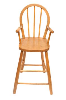Wooden high chair used to feed a baby or toddler with a spindle back isolated on white