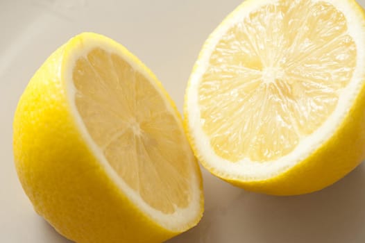 A lemon sliced in two on a grey background