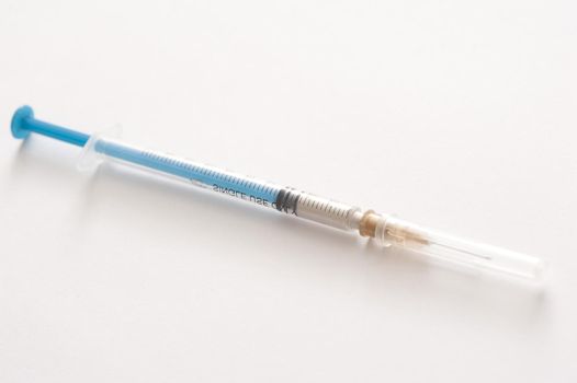 Small disposable plastic hypodermic syringe and injection needle for administering subcutaneous or intramuscular drugs