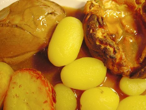 Close up background view of roast beef and potatoes in a gravy for a tasty dinner
