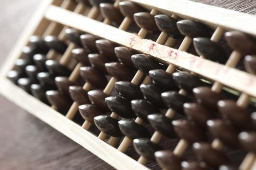 Traditional wooden abacus for manual computing in a close up view with focus to the counters at an oblique angle