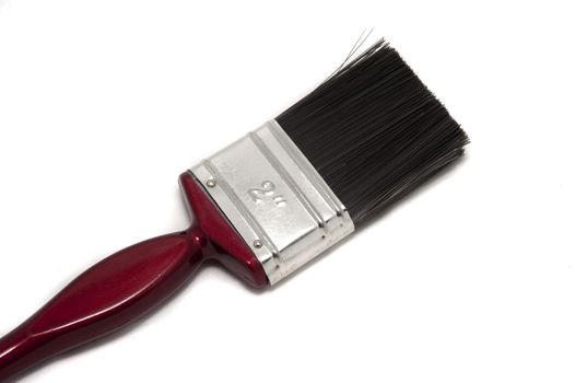 New unused paint brush for interior decorating and renovations lying diagonally on a white surface with copyspace