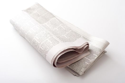 Folded newspaper on a white background lying diagonally with copy space either side