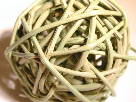Wicker ball texture composed of intertwined wattle wands or twigs, a rustic handicraft and decoration