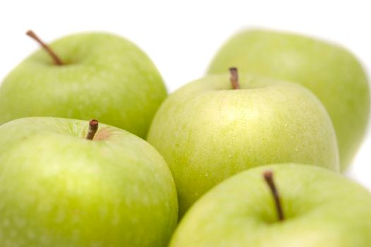 Close up of a group of crisp healthy fresh green apples over a white background