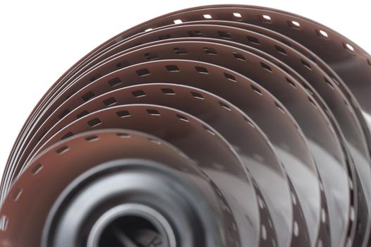 Extreme top down close up of uncoiled roll of 35 millimetre film over white background